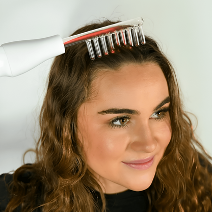 Woman using a hair dryer and brush on her hair against a white background